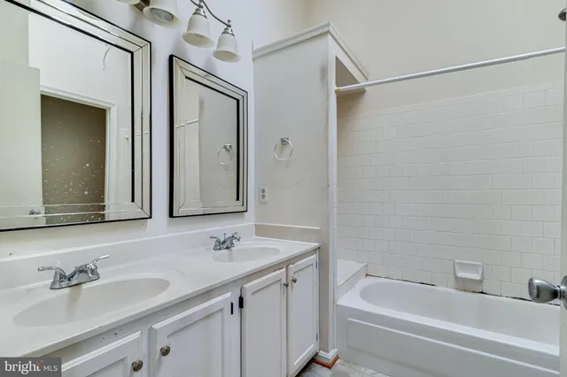 a bathroom with a granite countertop sink a mirror a bathtub and shower