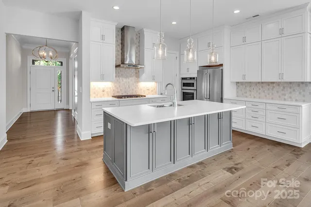 a kitchen with kitchen island white cabinets and stainless steel appliances