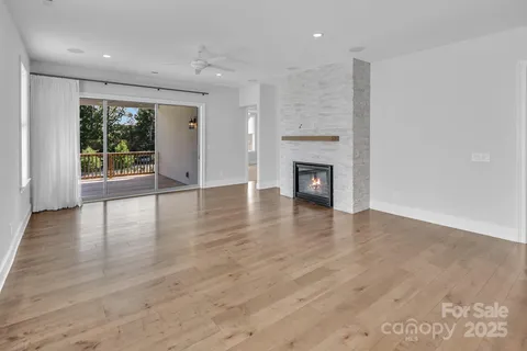 an empty room with wooden floor and a fireplace