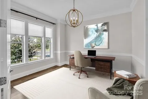 a workspace with furniture a chandelier and a window