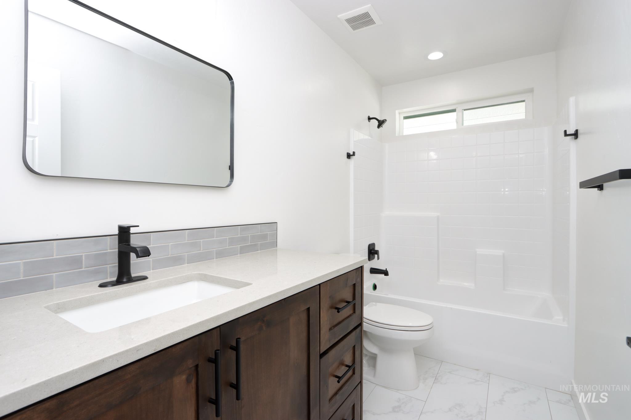 848 North 5th Street Nyssa, OR 97913 - Photo 27 of 49 Bathroom featuring a dark wood-finish vanity with a light countertop, an integrated rectangular sink, and matte black fixtures