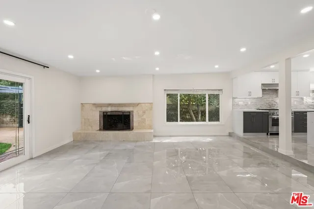 a view of an empty room with a fireplace and a window