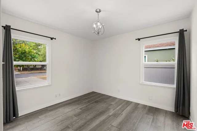 an empty room with a window and wooden floor