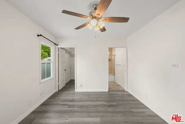 a view of a room with wooden floor and a ceiling fan