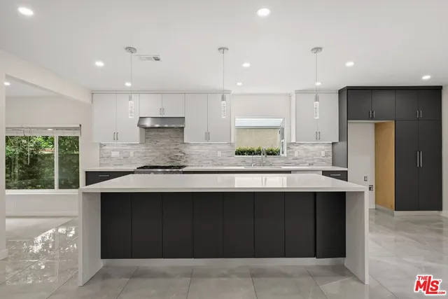 a kitchen with stainless steel appliances granite countertop a sink and a stove