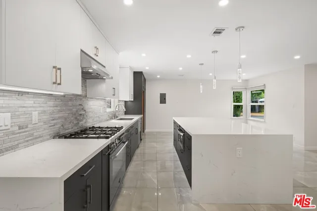 a kitchen with stainless steel appliances granite countertop a stove a sink and a refrigerator