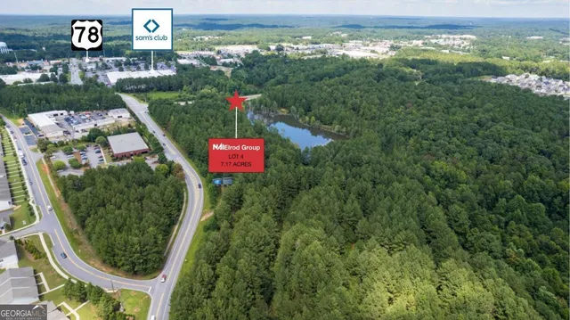 an aerial view of residential houses with outdoor space and trees