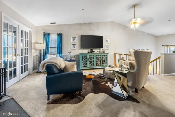a living room with furniture a flat screen tv and kitchen view