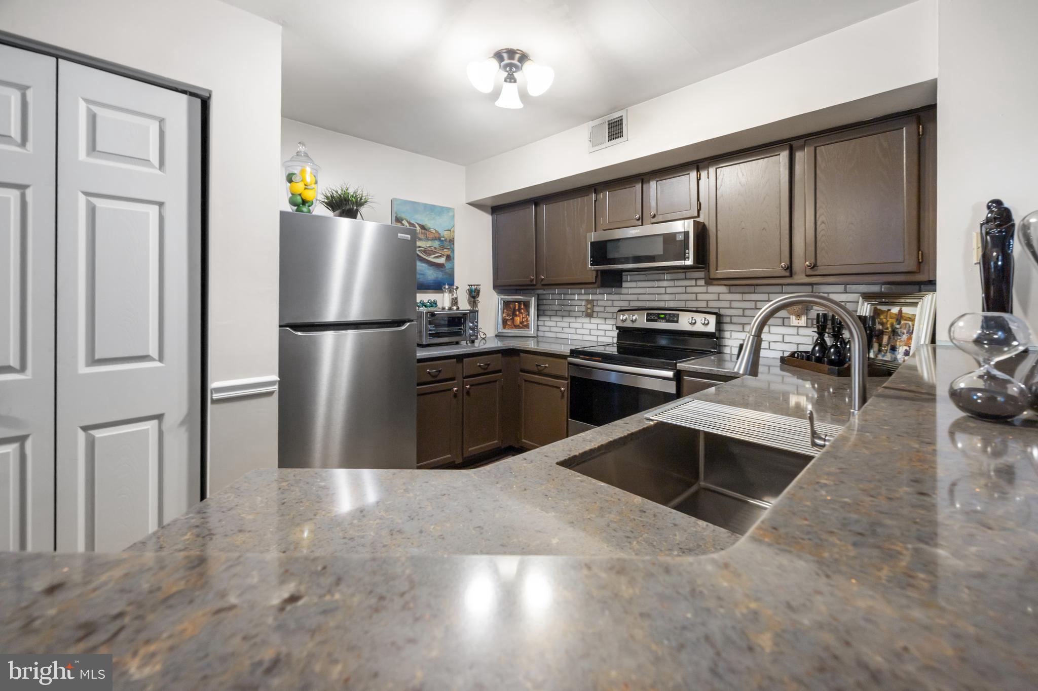 10 Sandstone Court Annapolis, MD 21403 - Photo 9 of 17 a kitchen with stainless steel appliances granite countertop a refrigerator a stove a sink and a microwave