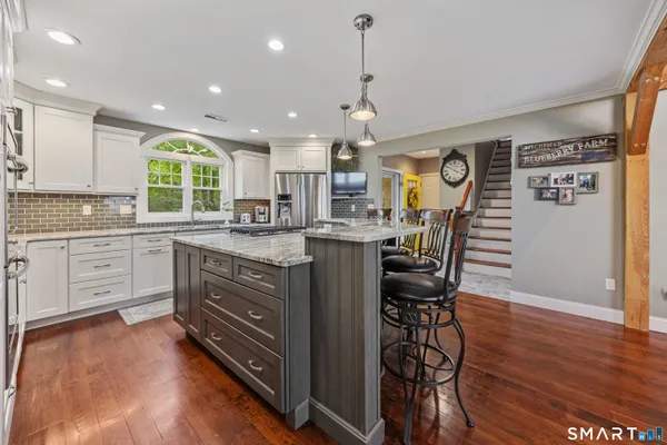 a kitchen with stainless steel appliances kitchen island granite countertop a stove a sink and a refrigerator