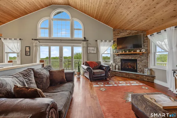 a living room with furniture a fireplace and a flat screen tv
