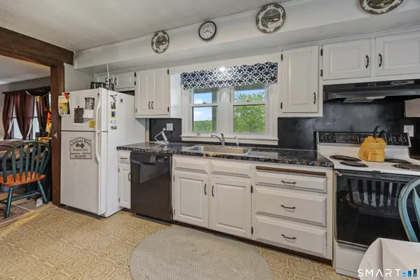 a kitchen with stainless steel appliances granite countertop a refrigerator a sink and a stove