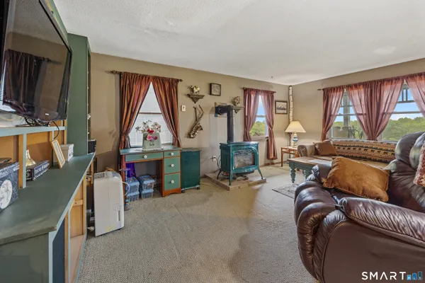 a living room with furniture a fireplace and a large window