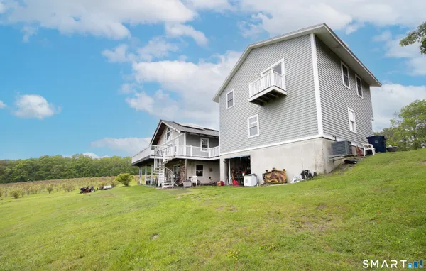 a view of a big house with a big yard and large trees
