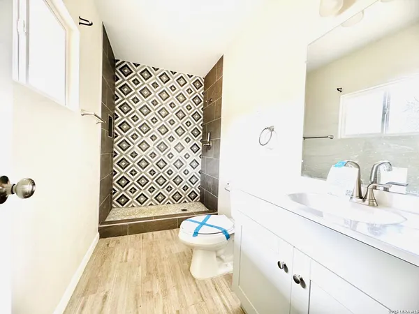 a bathroom with a sink toilet mirror and shower