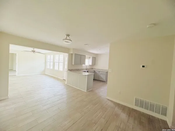 a view of a kitchen with a sink and dishwasher with white cabinets