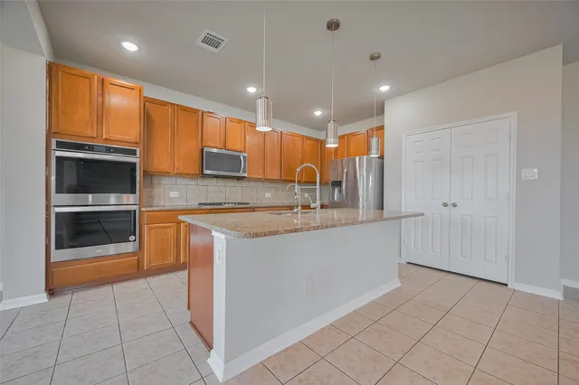 a large kitchen with stainless steel appliances lots of counter space and a sink