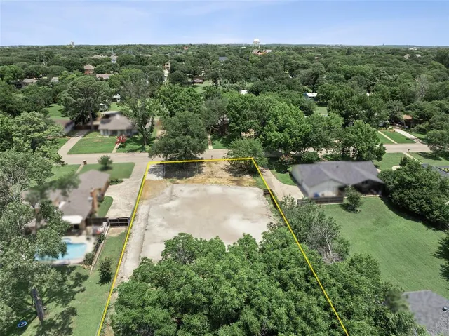 an aerial view of residential houses with outdoor space and trees