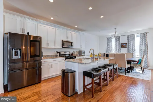 a kitchen with sink a refrigerator and wooden floor