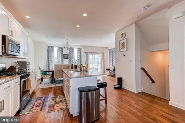a view of a dining room with furniture a rug and wooden floor