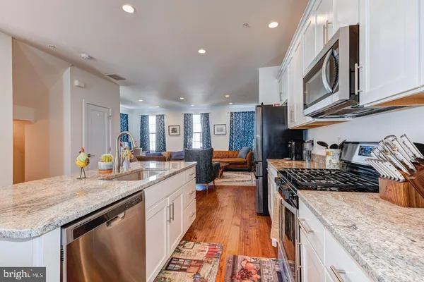 a kitchen with stainless steel appliances granite countertop a sink stove and cabinets