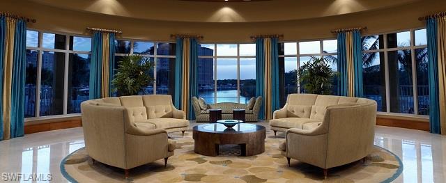 13665 Vanderbilt Drive, Unit 701 Naples, FL 34110 - Photo 11 of 22 a living room with furniture and large windows