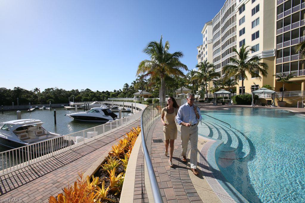 13665 Vanderbilt Drive, Unit 701 Naples, FL 34110 - Photo 19 of 22 a view of a lake with a deck