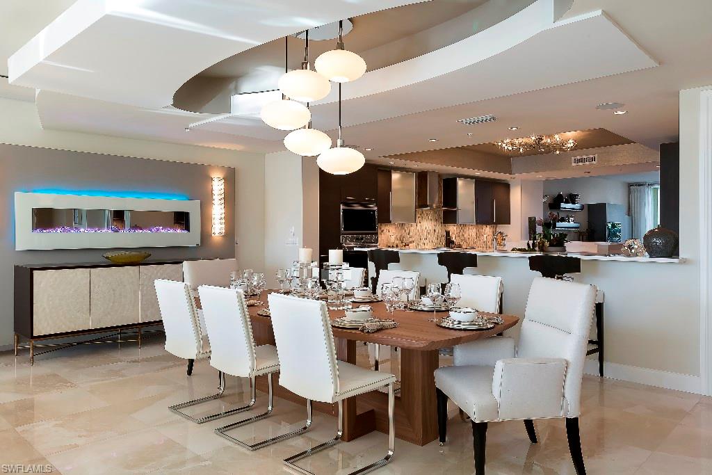 13665 Vanderbilt Drive, Unit 701 Naples, FL 34110 - Photo 2 of 22 a view of a dining room with furniture and wooden floor