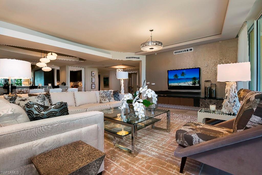 13665 Vanderbilt Drive, Unit 701 Naples, FL 34110 - Photo 3 of 22 a living room with furniture and a fireplace