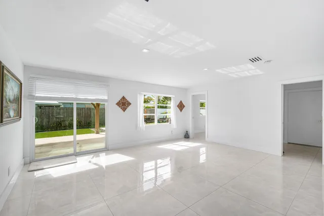 an empty room with a ceiling fan and window