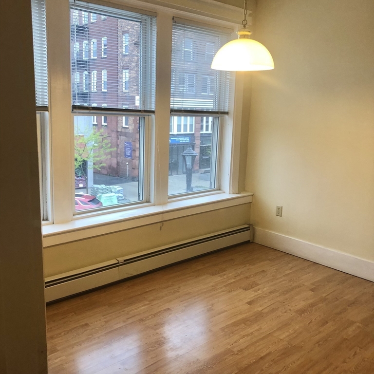 27 High Street, Unit 1 Clinton, MA 01510 - Photo 7 of 30 a view of an empty room with a window and wooden floor