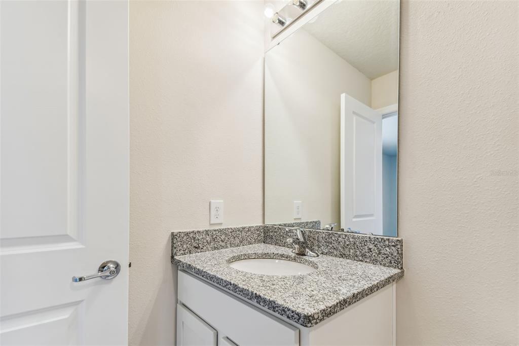 6793 Southwest 90th Loop Ocala, FL 34476 - Photo 18 of 23 a bathroom with a granite countertop sink and a mirror