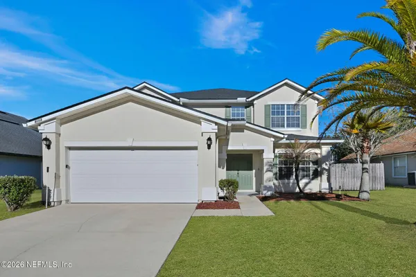 a front view of house with yard and green space