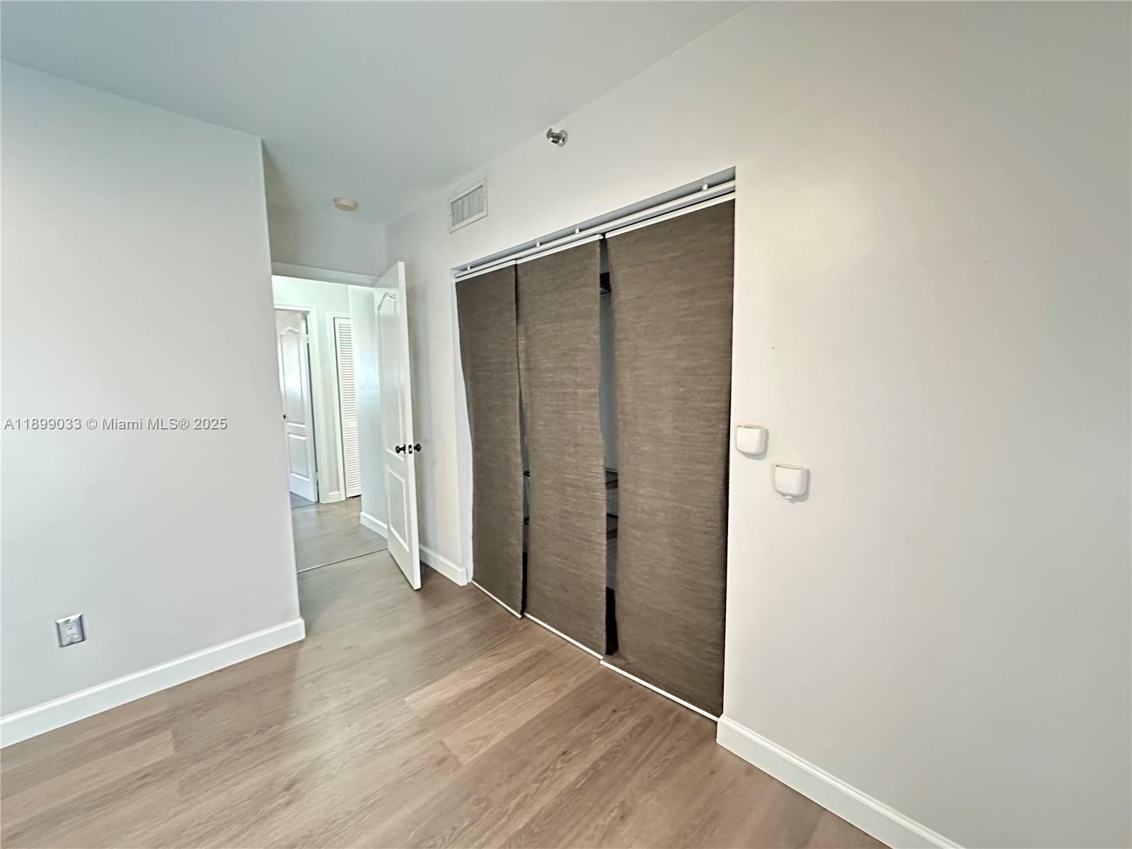 677 Northeast 24th Street, Unit 406 Miami, FL 33137 - Photo 11 of 15 an empty room with wooden floor