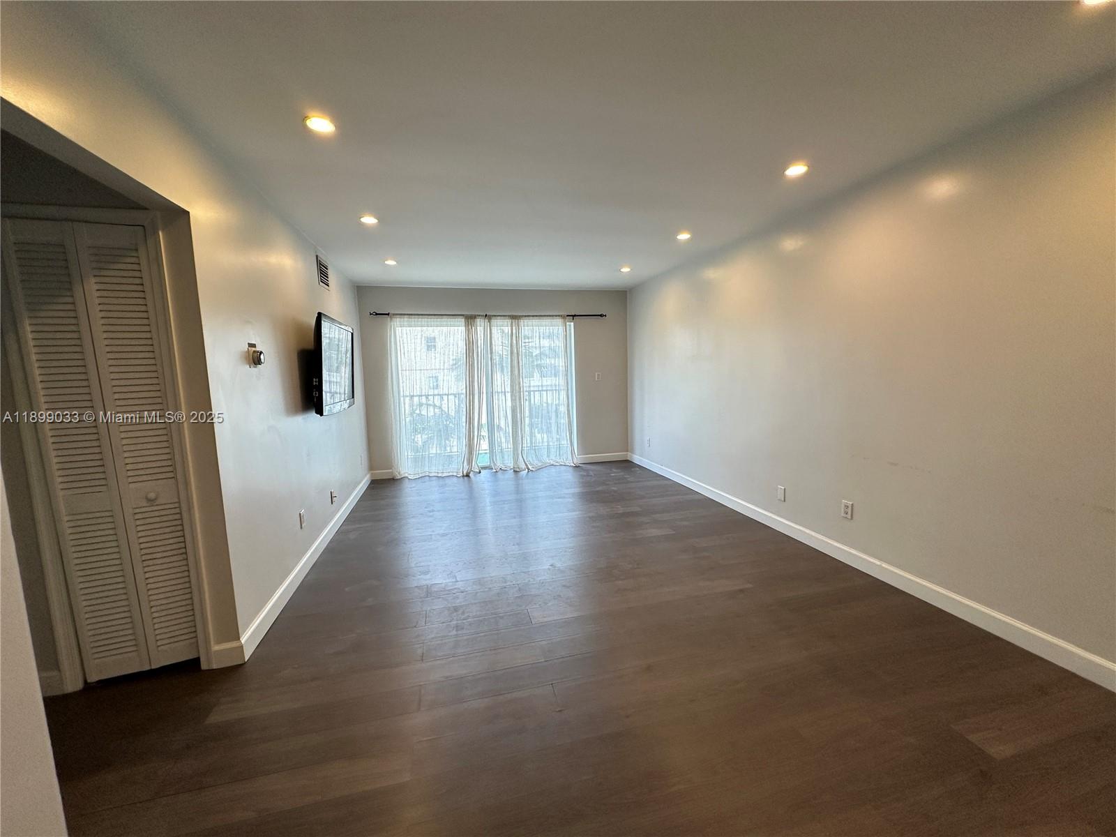 677 Northeast 24th Street, Unit 406 Miami, FL 33137 - Photo 2 of 15 an empty room with wooden floor and windows