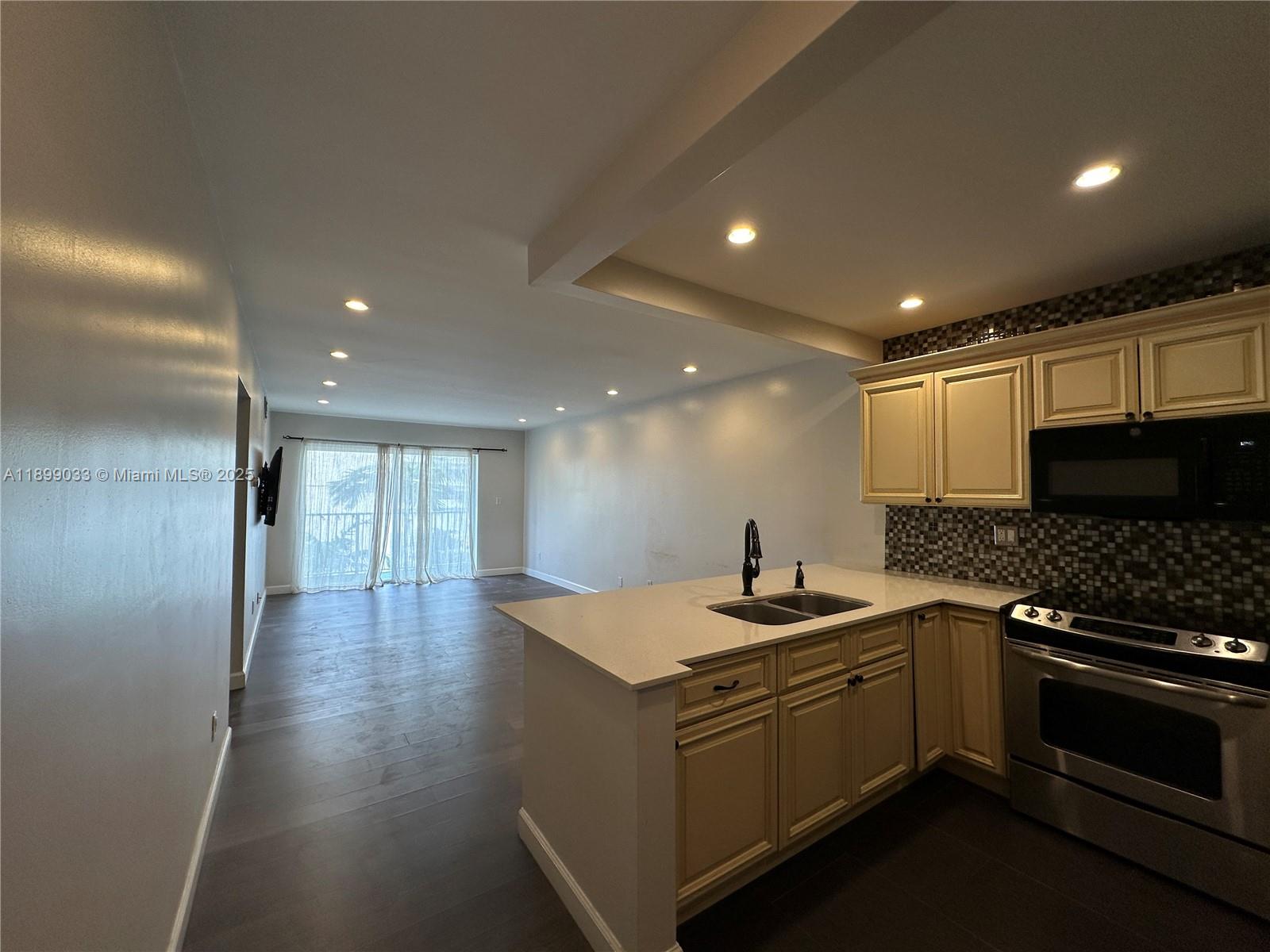 677 Northeast 24th Street, Unit 406 Miami, FL 33137 - Photo 3 of 15 a kitchen with a sink stove and cabinets