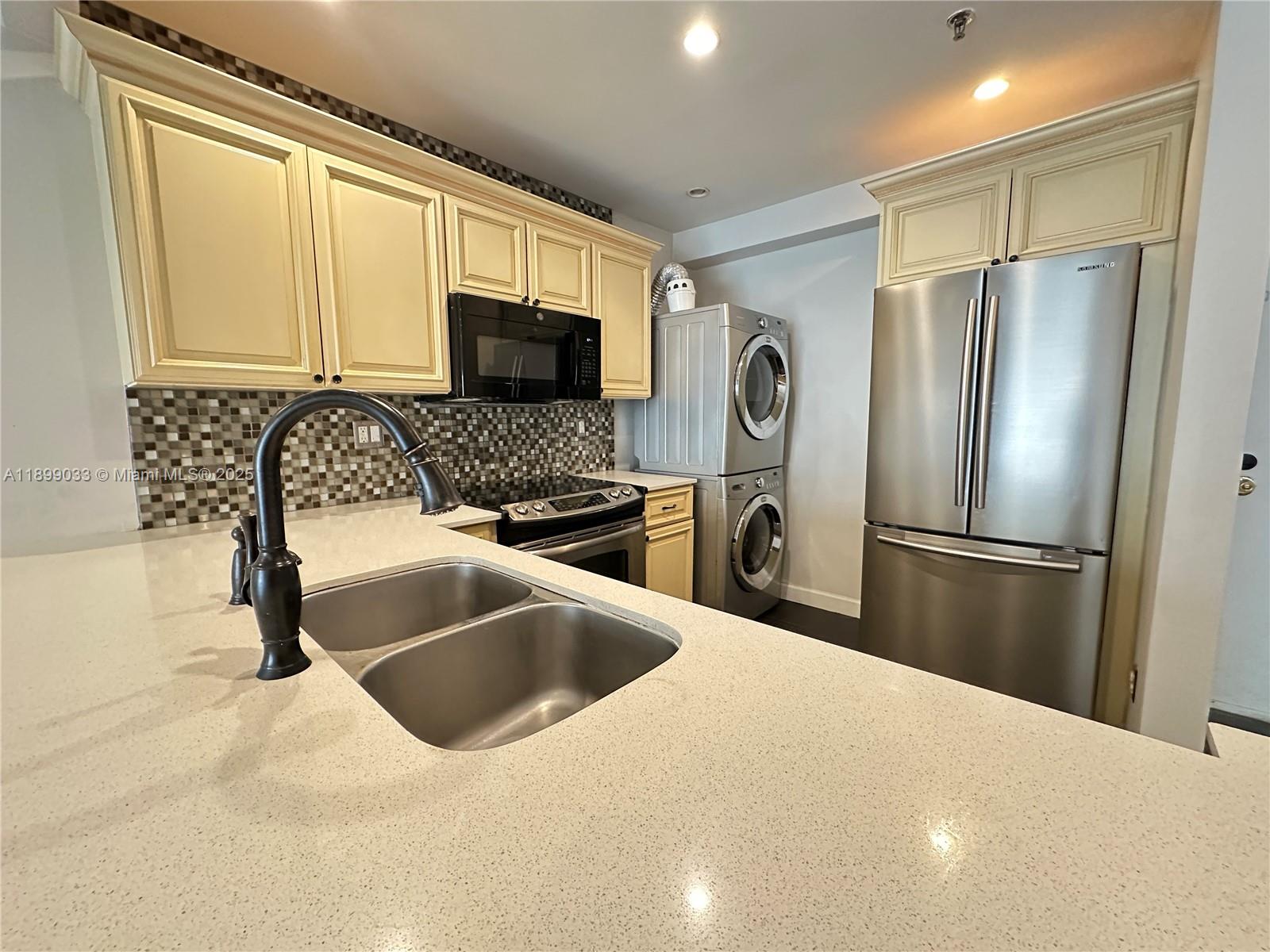 677 Northeast 24th Street, Unit 406 Miami, FL 33137 - Photo 5 of 15 a kitchen with stainless steel appliances a refrigerator sink and microwave