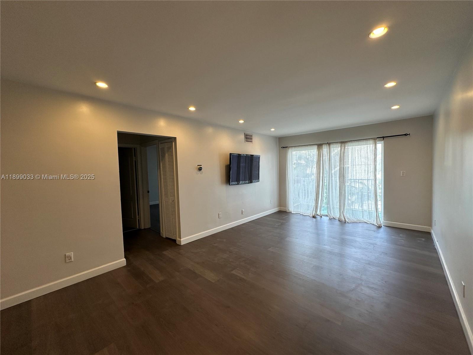 677 Northeast 24th Street, Unit 406 Miami, FL 33137 - Photo 6 of 15 an empty room with wooden floor and windows