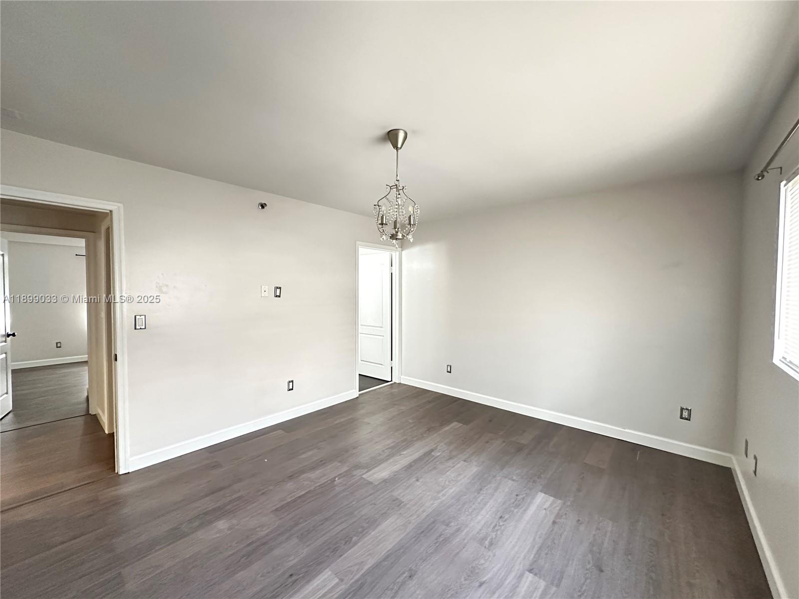 677 Northeast 24th Street, Unit 406 Miami, FL 33137 - Photo 7 of 15 an empty room with wooden floor and windows