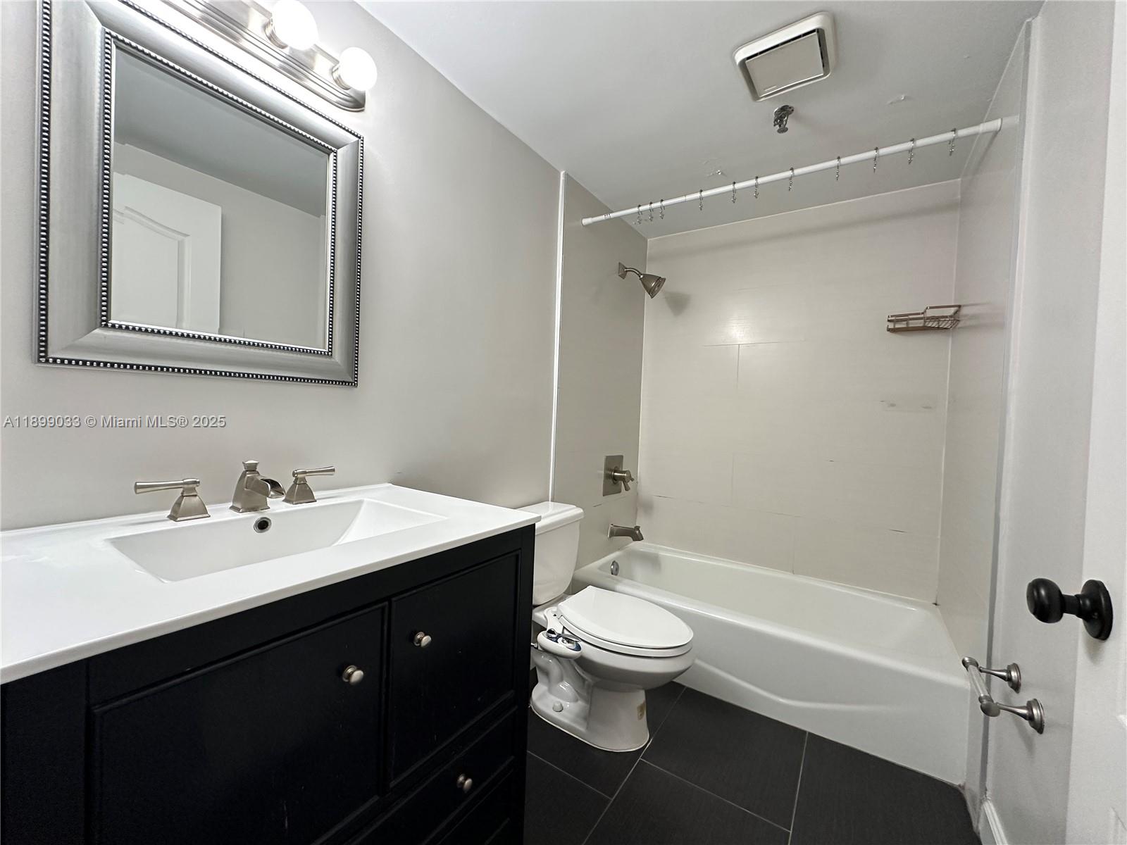 677 Northeast 24th Street, Unit 406 Miami, FL 33137 - Photo 8 of 15 a bathroom with a double vanity sink toilet mirror and bathtub