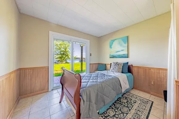 a bed sitting in a bedroom next to a window