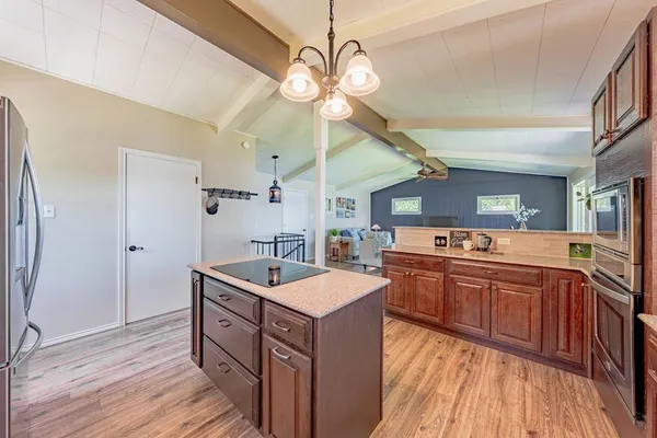 a kitchen with a sink stove and wooden floor