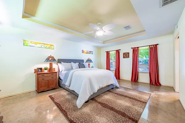 a spacious bedroom with a bed and a chandelier