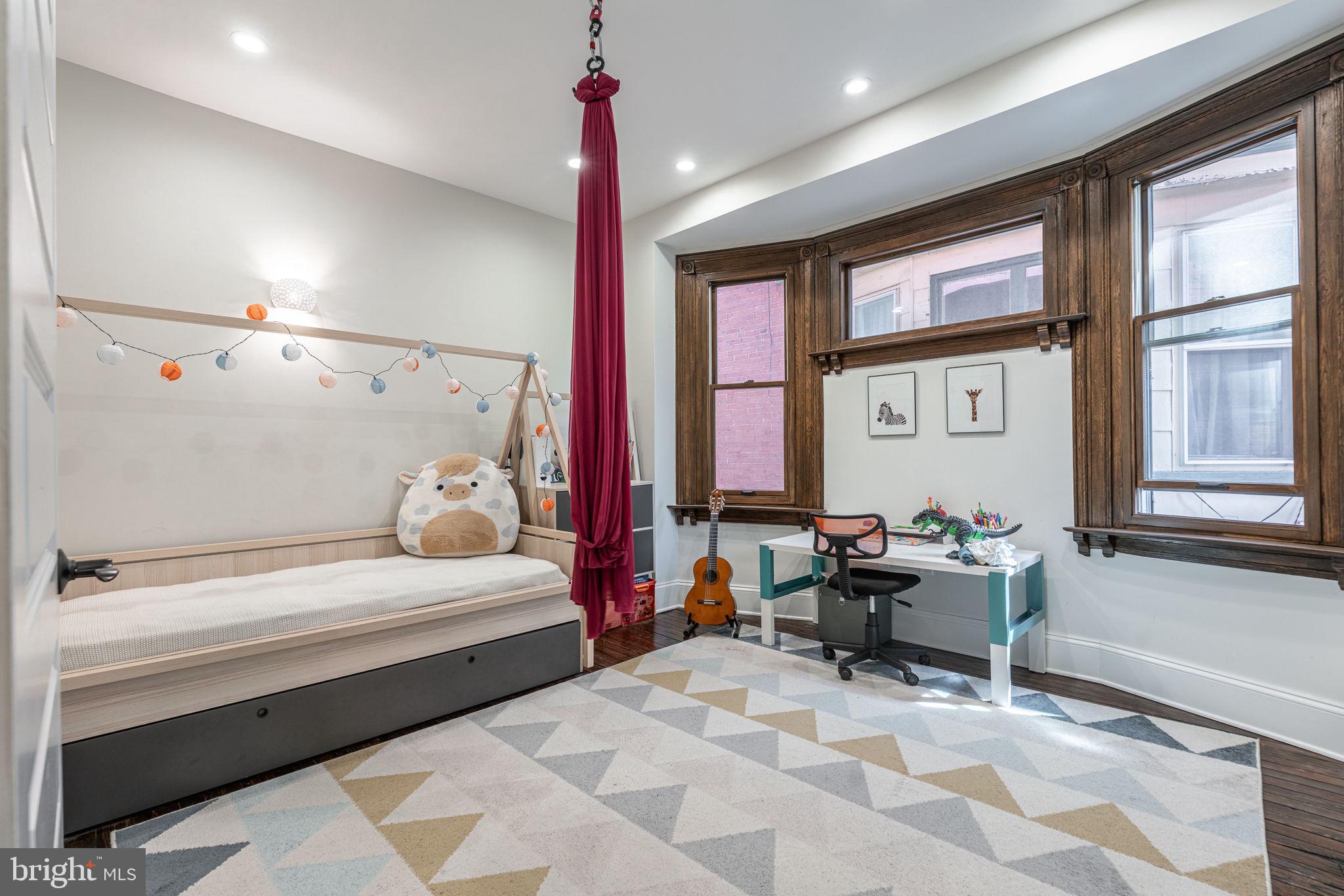 239 South 46th Street Philadelphia, PA 19139 - Photo 19 of 34 a bedroom with a bed and large windows