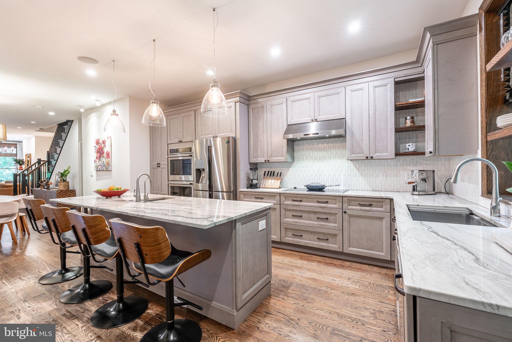239 South 46th Street Philadelphia, PA 19139 - Photo 9 of 34 a kitchen with stainless steel appliances granite countertop a table chairs sink and cabinets