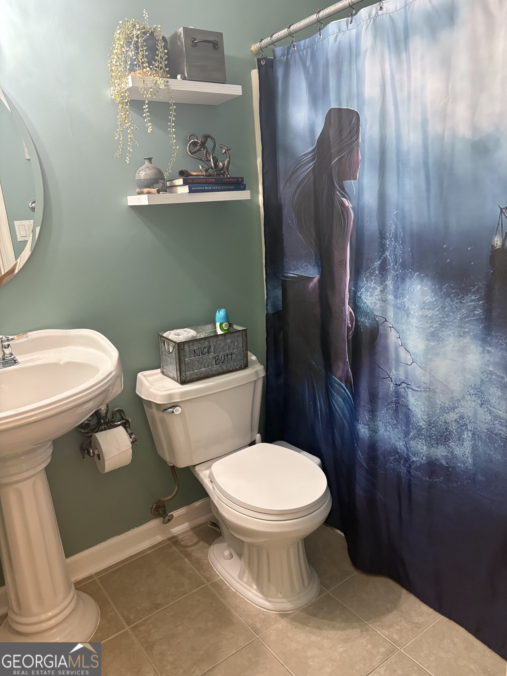 206 Oxford Road Griffin, GA 30223 - Photo 25 of 34 a white toilet sitting next to a bathroom sink and a mirror