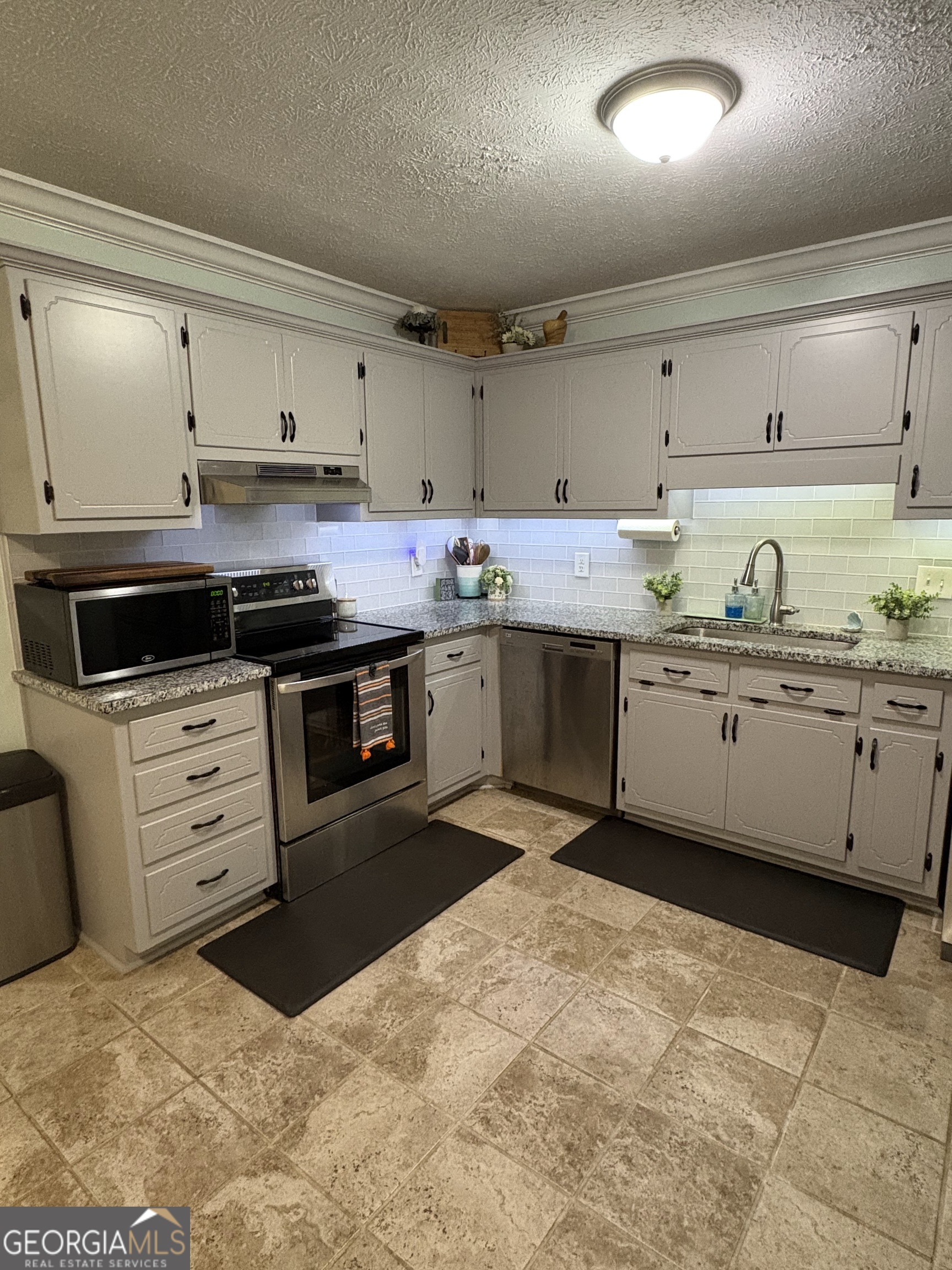 206 Oxford Road Griffin, GA 30223 - Photo 10 of 34 a kitchen with stainless steel appliances granite countertop a sink and cabinets