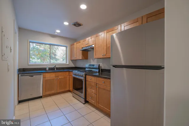 a kitchen with stainless steel appliances granite countertop a refrigerator sink and stove