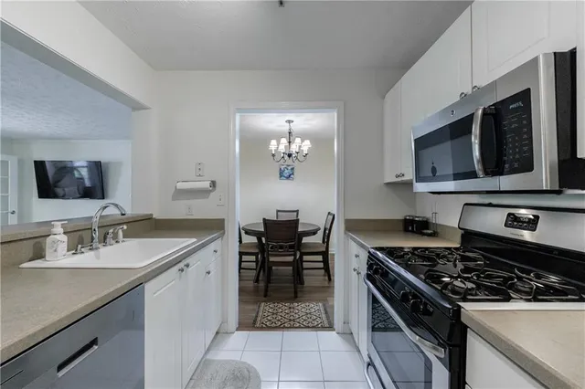 a kitchen with stainless steel appliances a sink stove and microwave