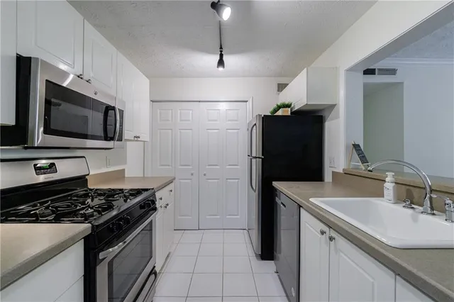 a kitchen with a sink stove and refrigerator